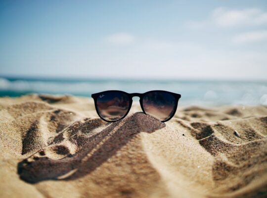 sunglasses on sand at beach